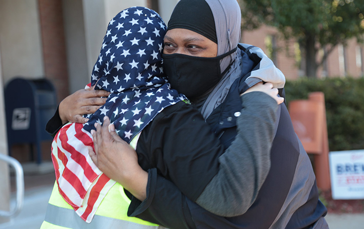 Christine Mohamed, executive director of CAIR Pittsburgh and a Common Cause volunteer, embraces Carla McClellan, who had just voted in Clairton. (Photo by Ryan Loew/PublicSource)